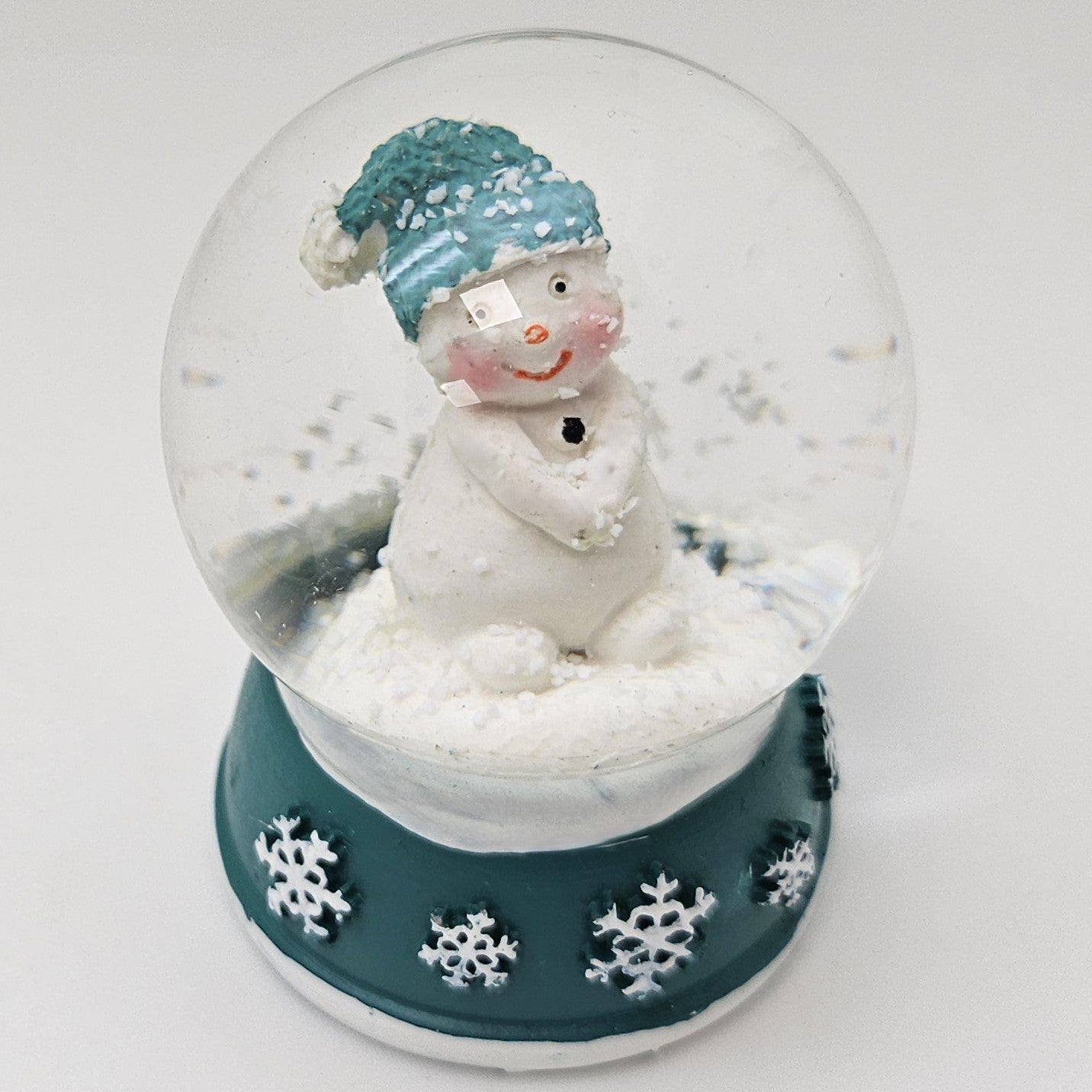 Süße Mini - Schneekugel Schneemann Hände zusammen auf Sockel türkis weiße Schneeeflocke B: 45mm - Schneekugelhaus